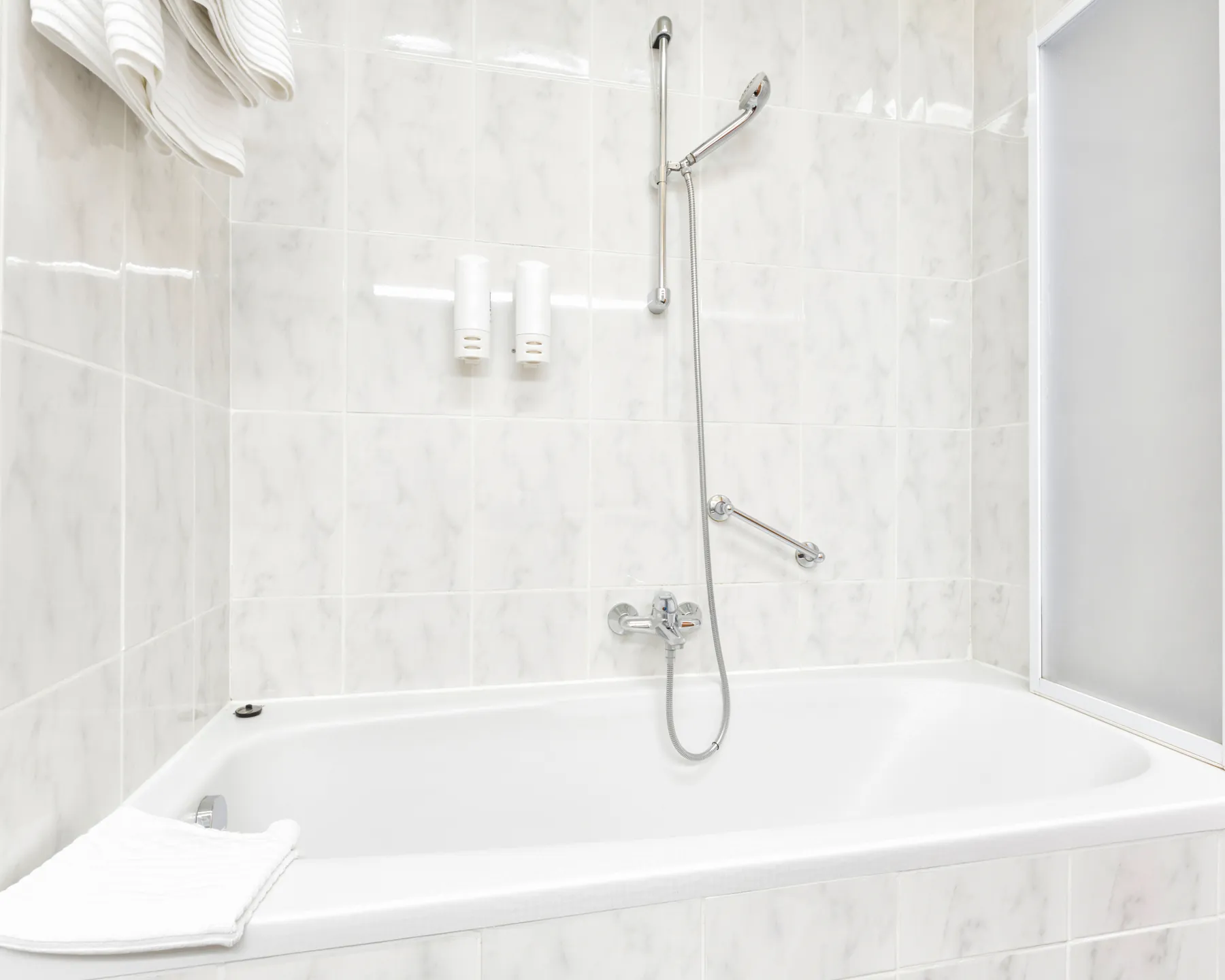 A finished bathtub with marble-look tile surround, shown as a placeholder example of a refreshed space.