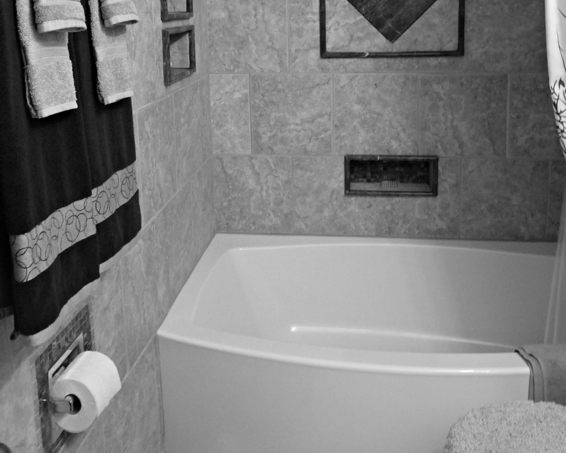 Placeholder before image of a built-in bathtub and tiled surround.